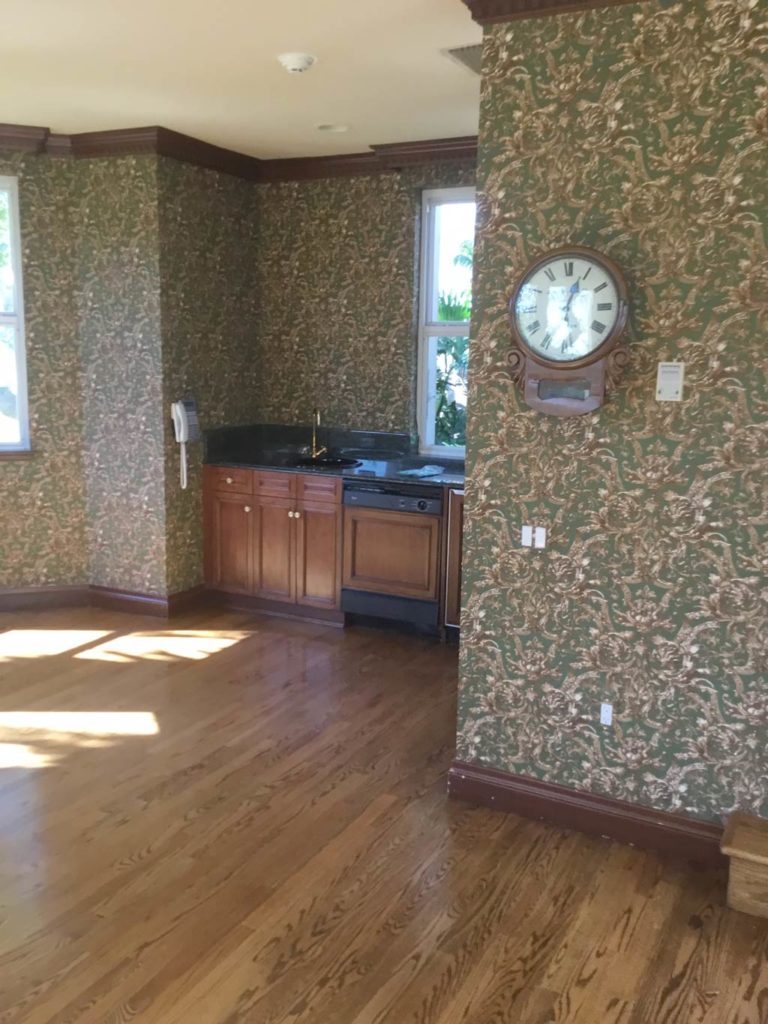 Before photo of kitchenette and dining room with wallpaper